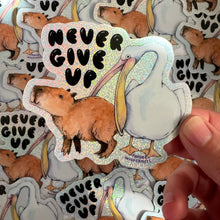 Load image into Gallery viewer, Never Give Up Capybara Pelican Holographic Glitter Vinyl Die Cut Durable Sticker
