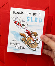 Load image into Gallery viewer, Hanging On By A Sled Winter Sledding Holiday Card