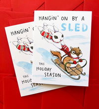 Load image into Gallery viewer, Hanging On By A Sled Winter Sledding Holiday Card